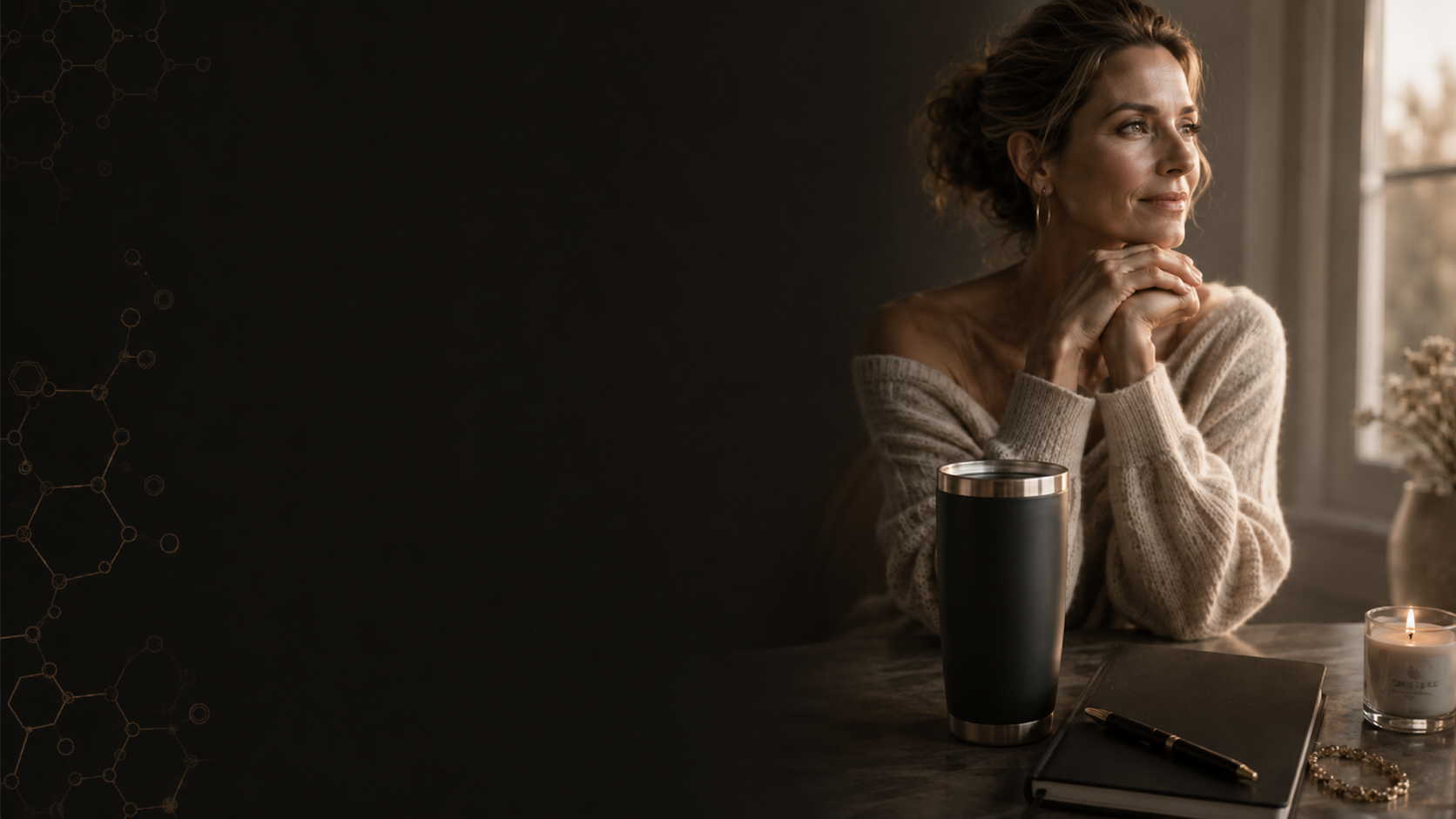 Woman by a window with a candle and journal