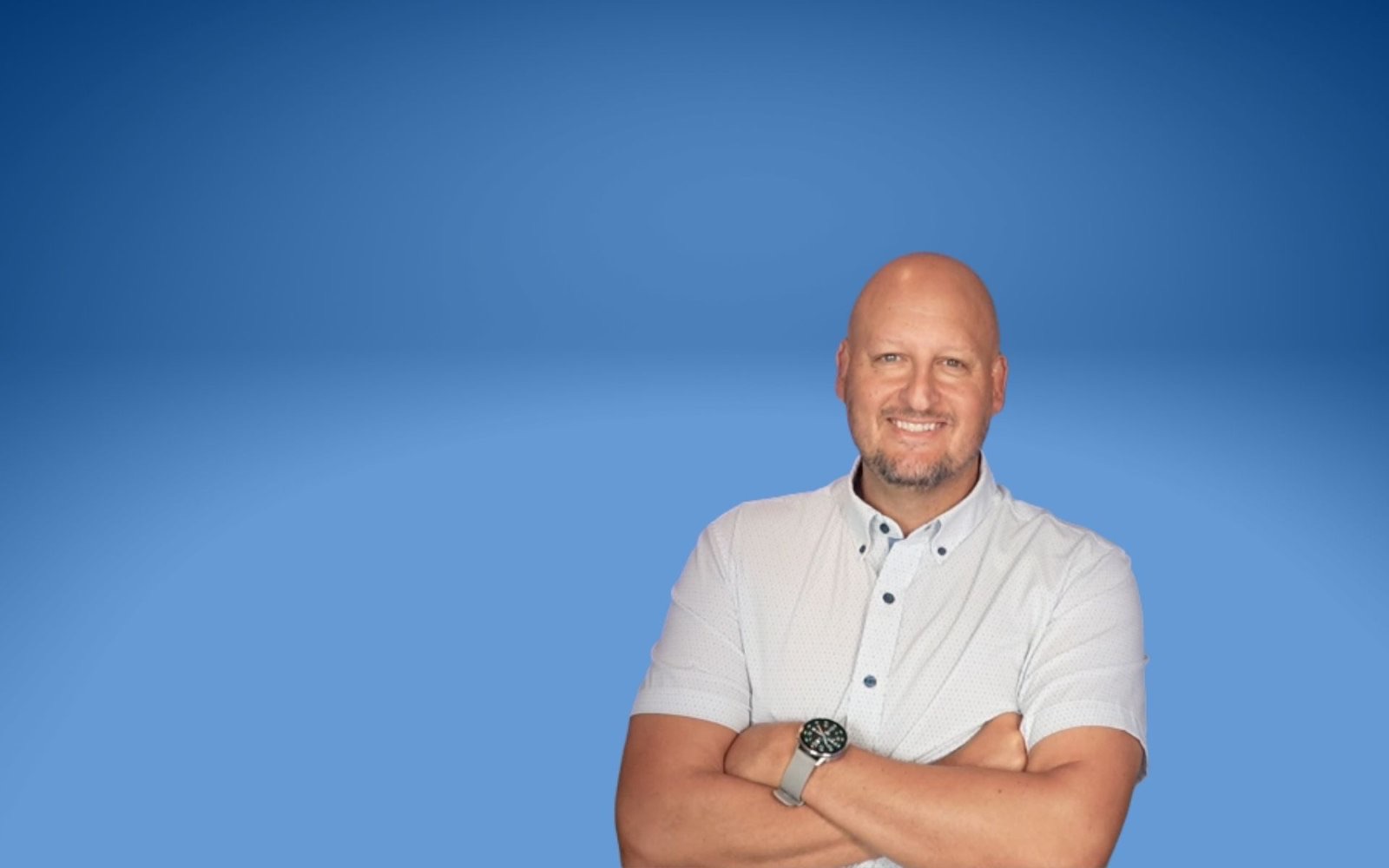 Todd Wall, arms crossed, in front of a blue studio backdrop