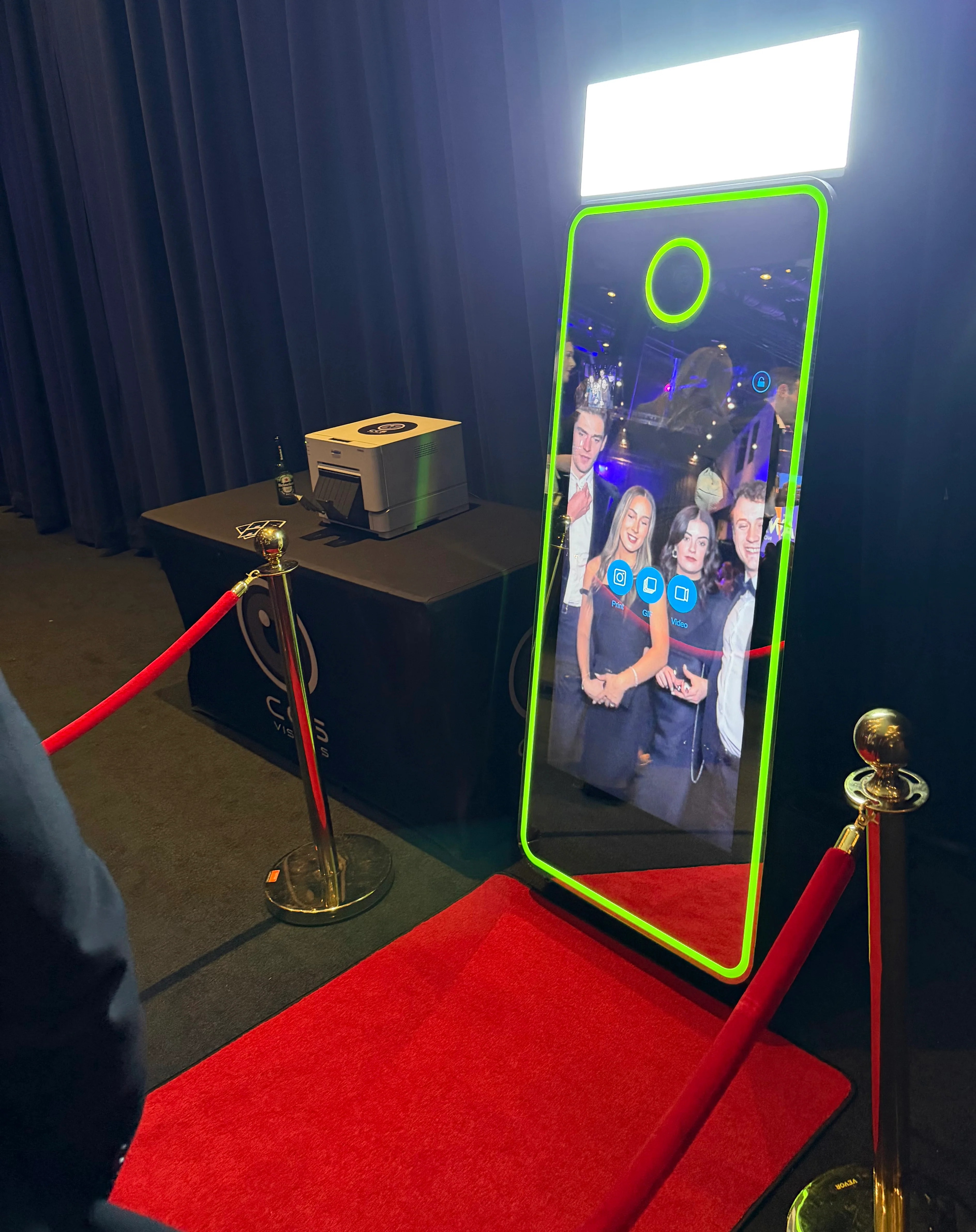 The Snapped magic mirror photo booth glowing at a dark wedding reception in Cornwall, with red carpet and Touch to Start screen