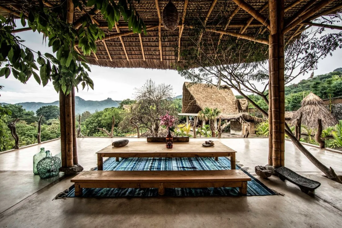 A thatched pavilion with a low table looking out over the valley at the Vādma training venue near Mexico City