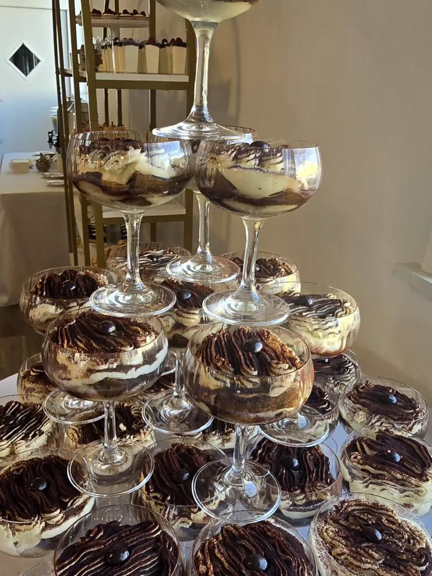 Tower of layered desserts in glass cups at the reception