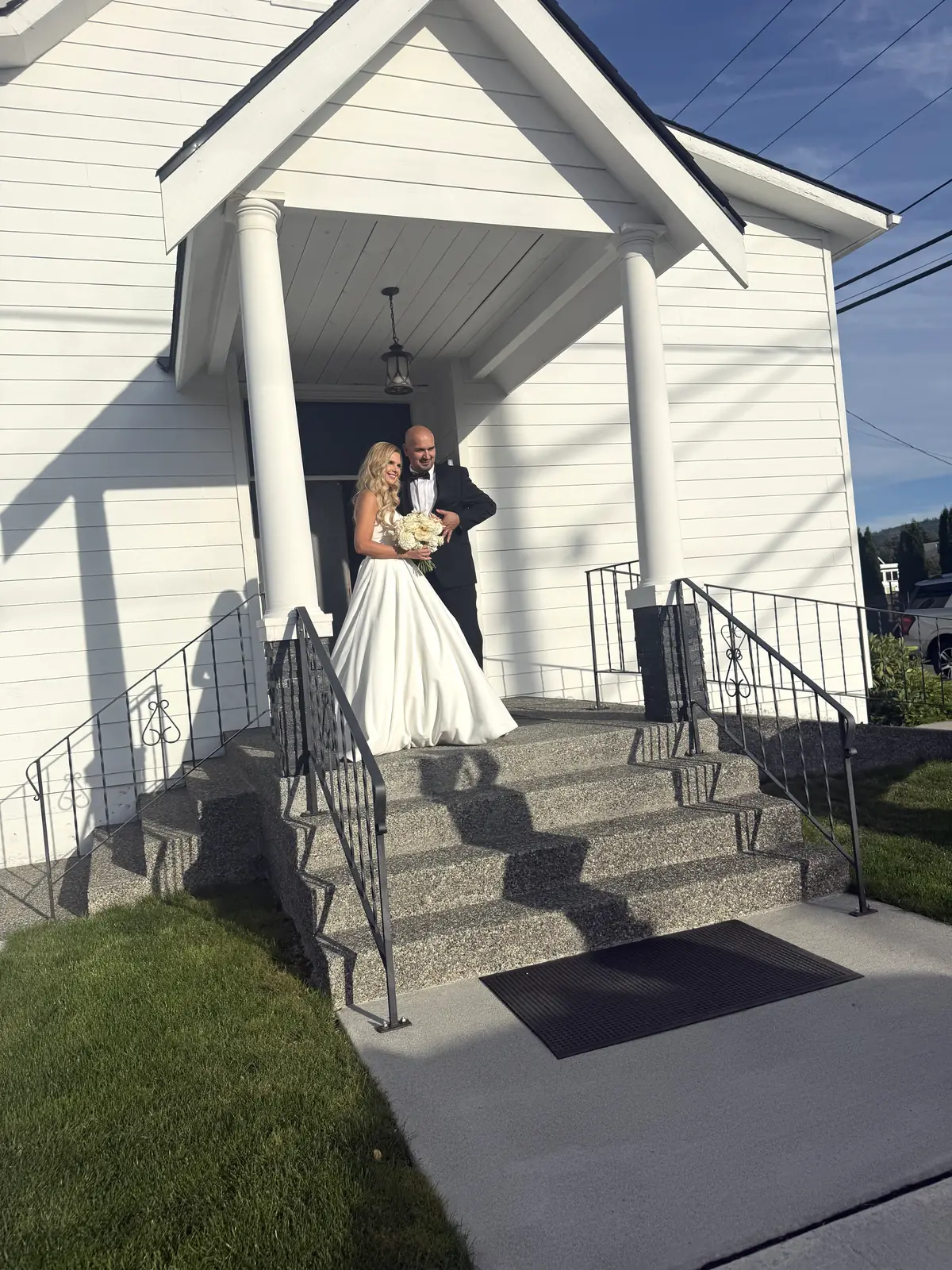 Bride and groom on the front steps of Madison Hill Chapel in Monroe, WA