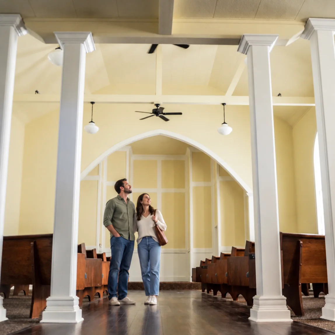 A couple exploring the Madison Hill Chapel interior, standing beneath the pointed-arch architecture during a venue tour