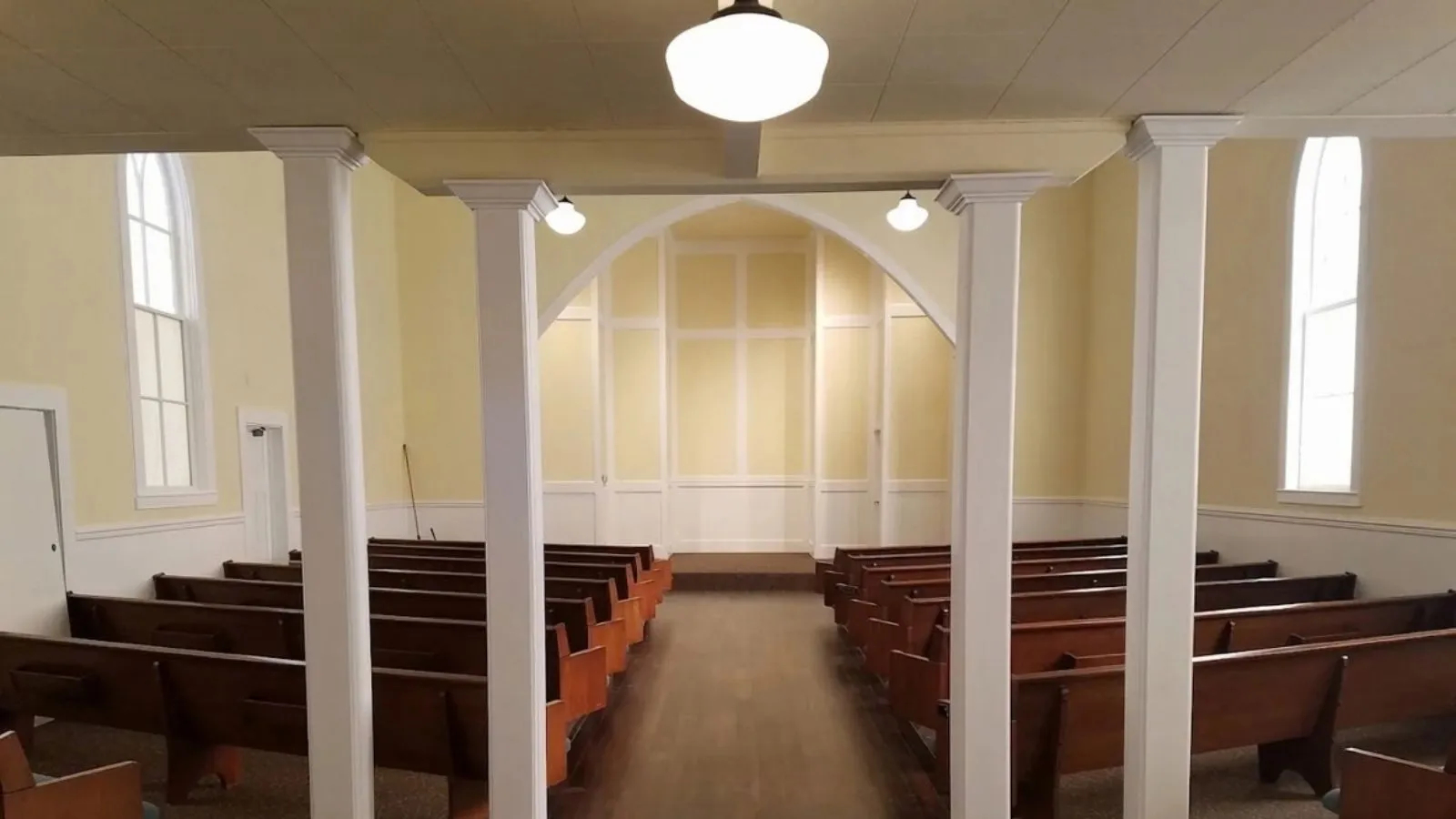 Inside the historic chapel with wooden pews and an arched front