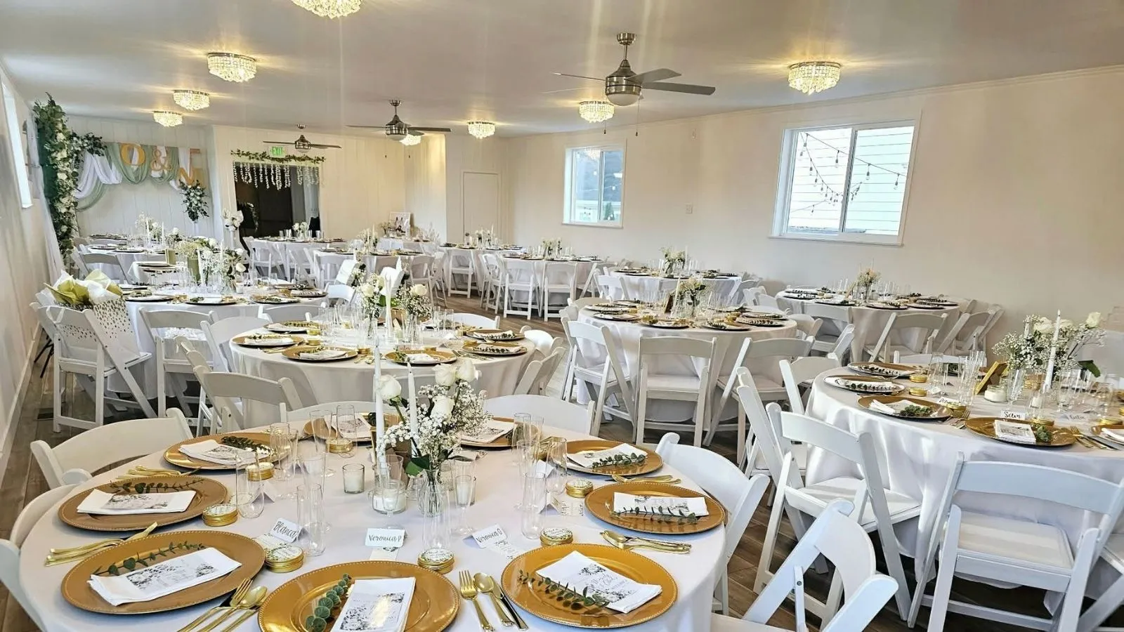 Reception hall set for a wedding with round tables and chandeliers
