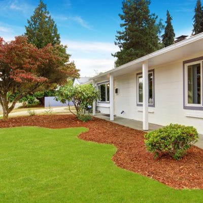 Front yard with fresh mulch and a well-maintained lawn.