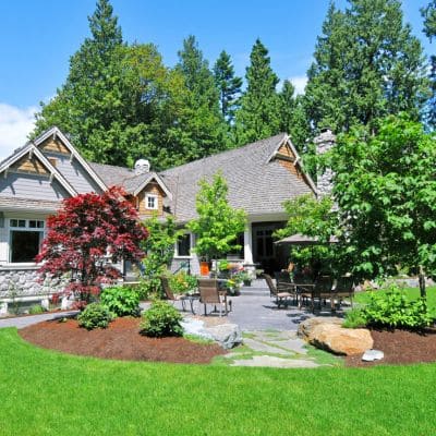 Beautifully landscaped backyard with vibrant greenery and patio seating.