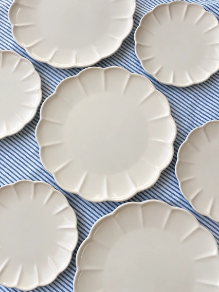 Cream Scalloped side Plates over blue table cloth