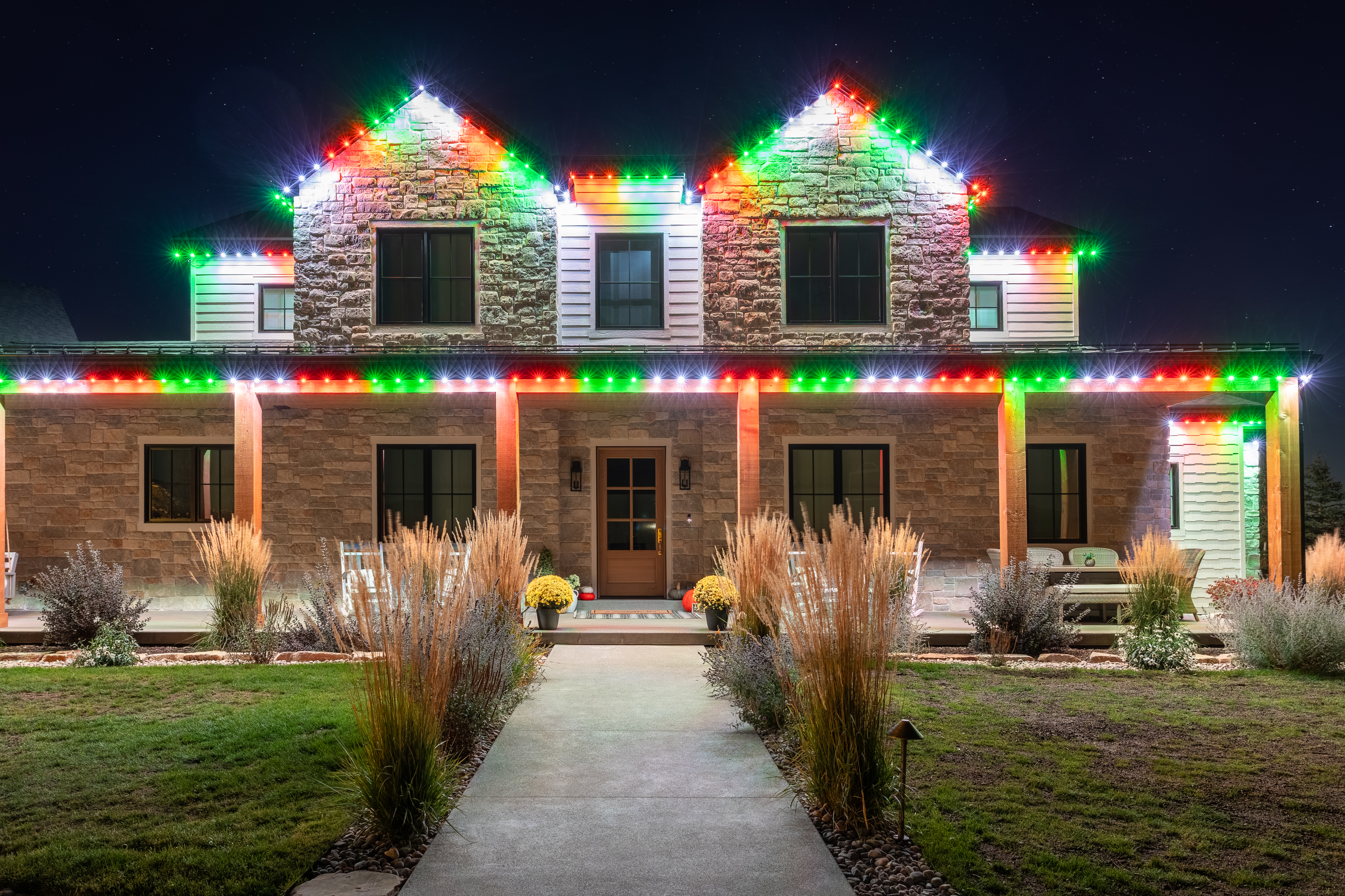 The same home at night lit in red, green and white holiday colors