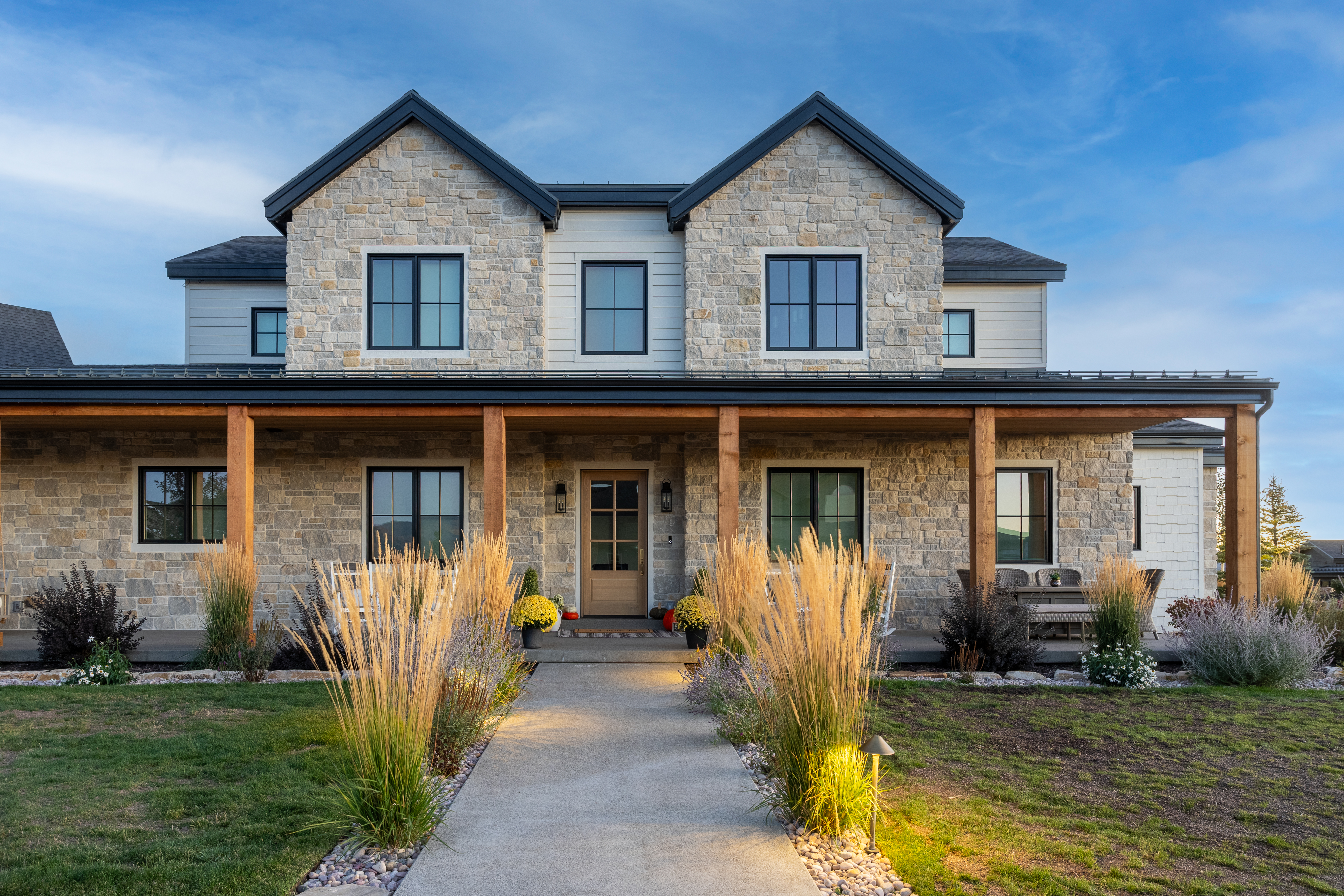 Stone home during the day with permanent lighting hidden in the roofline