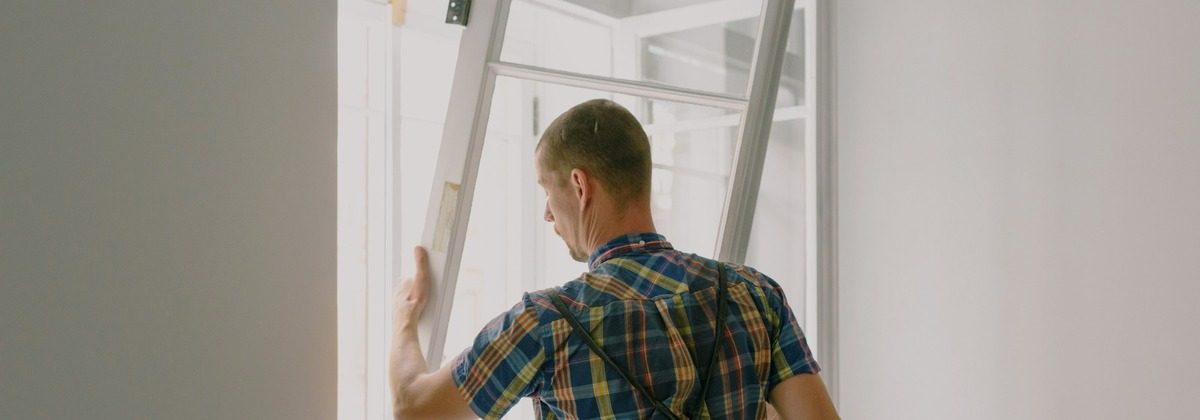 Installer fitting a new window during a home renovation