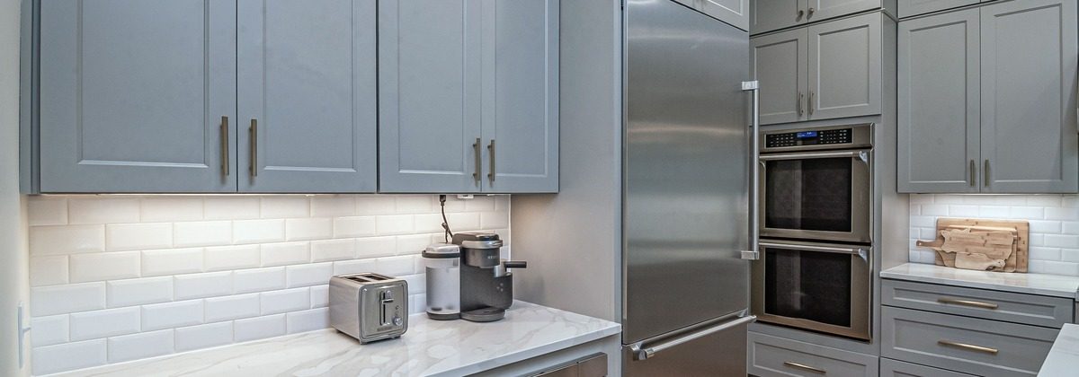 Finished kitchen with shaker cabinets and marble countertop