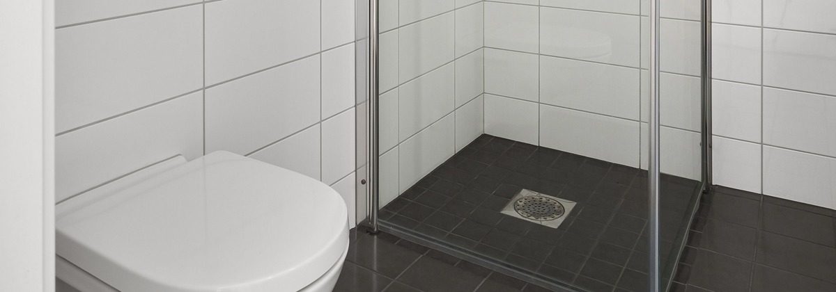 Curbless walk-in shower with floor tile running level into the enclosure