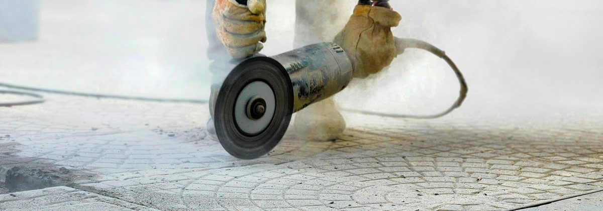 Angle grinder working a concrete paving slab