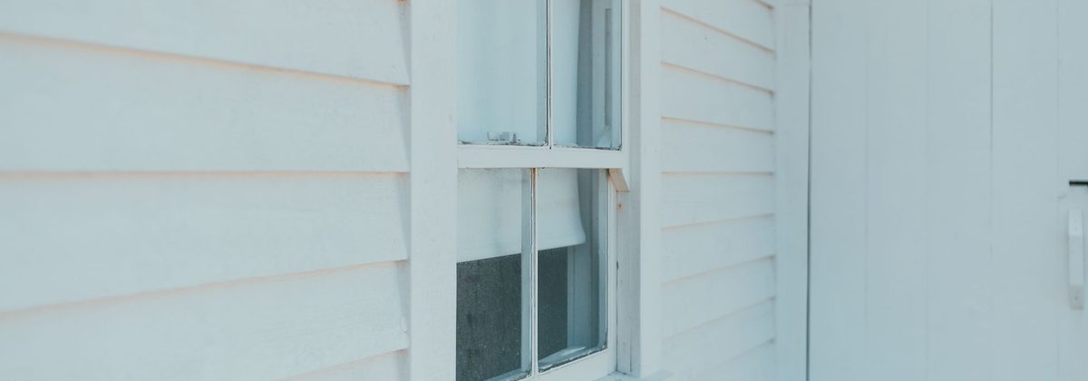 Close-up of new white lap siding around a window