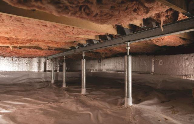 Moist crawl space environment beneath a home where damp soil and humidity can contribute to musty odors.