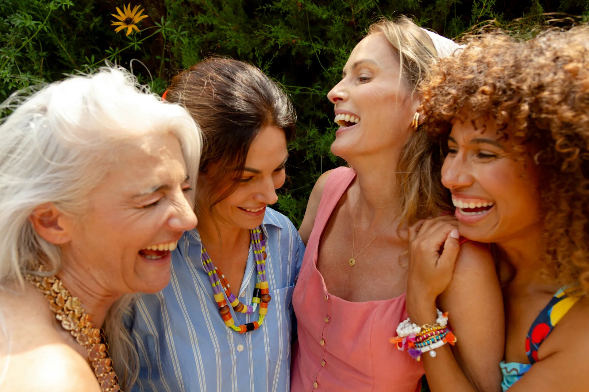 Four women laughing together outdoors