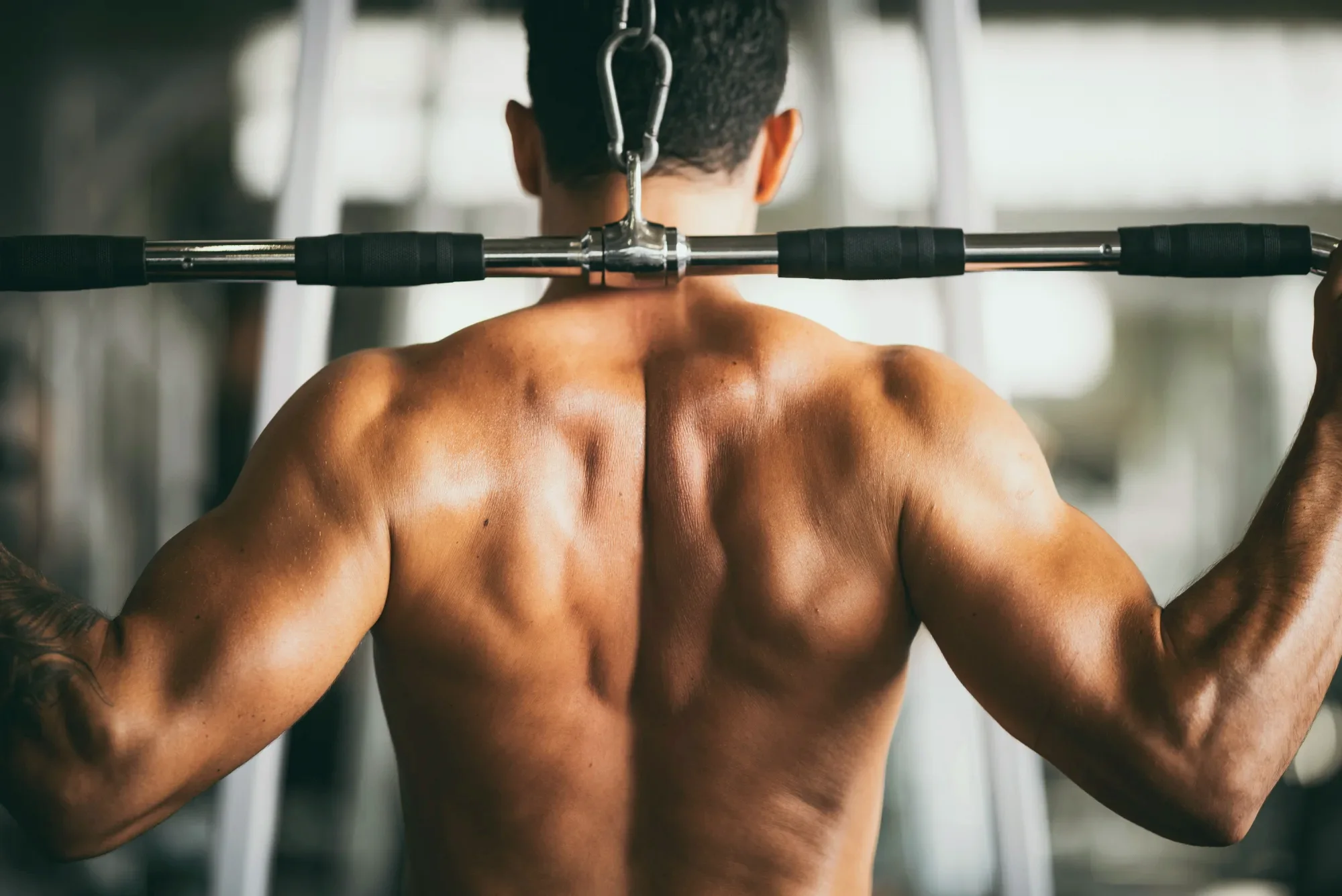 Muscular man doing a cable lat pulldown, representing strength and energy goals for men's testosterone therapy at Lexel Aesthetics in Dunn, NC
