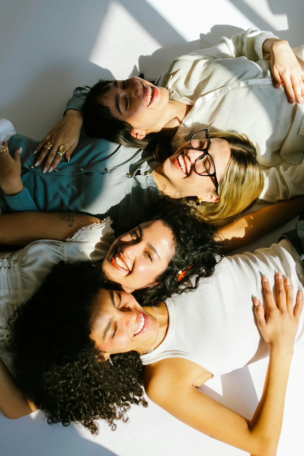 Four friends smiling while lying down together