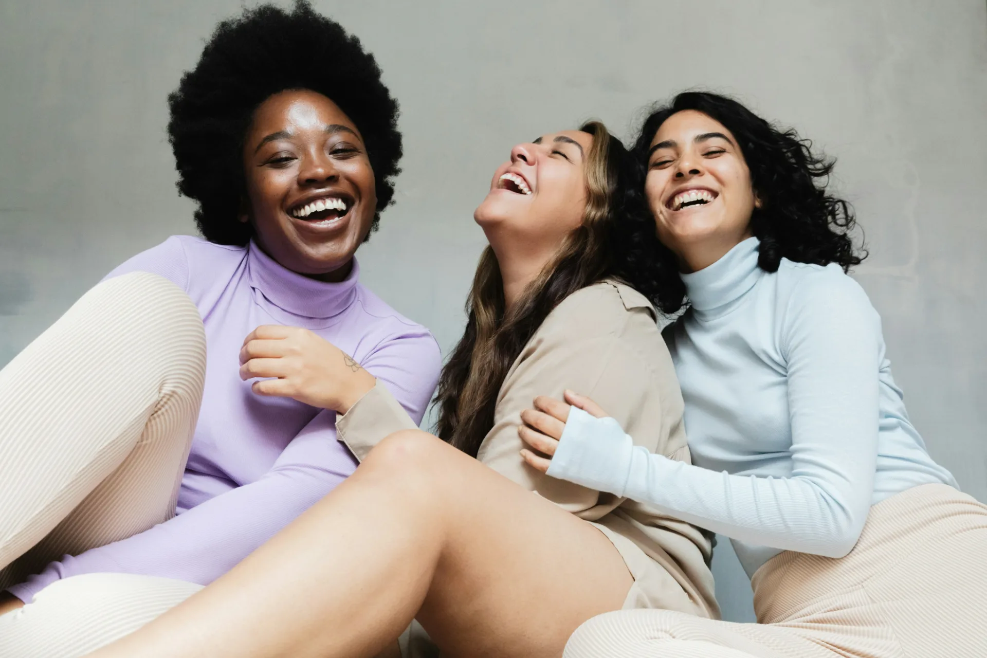 Three women laughing while sitting together
