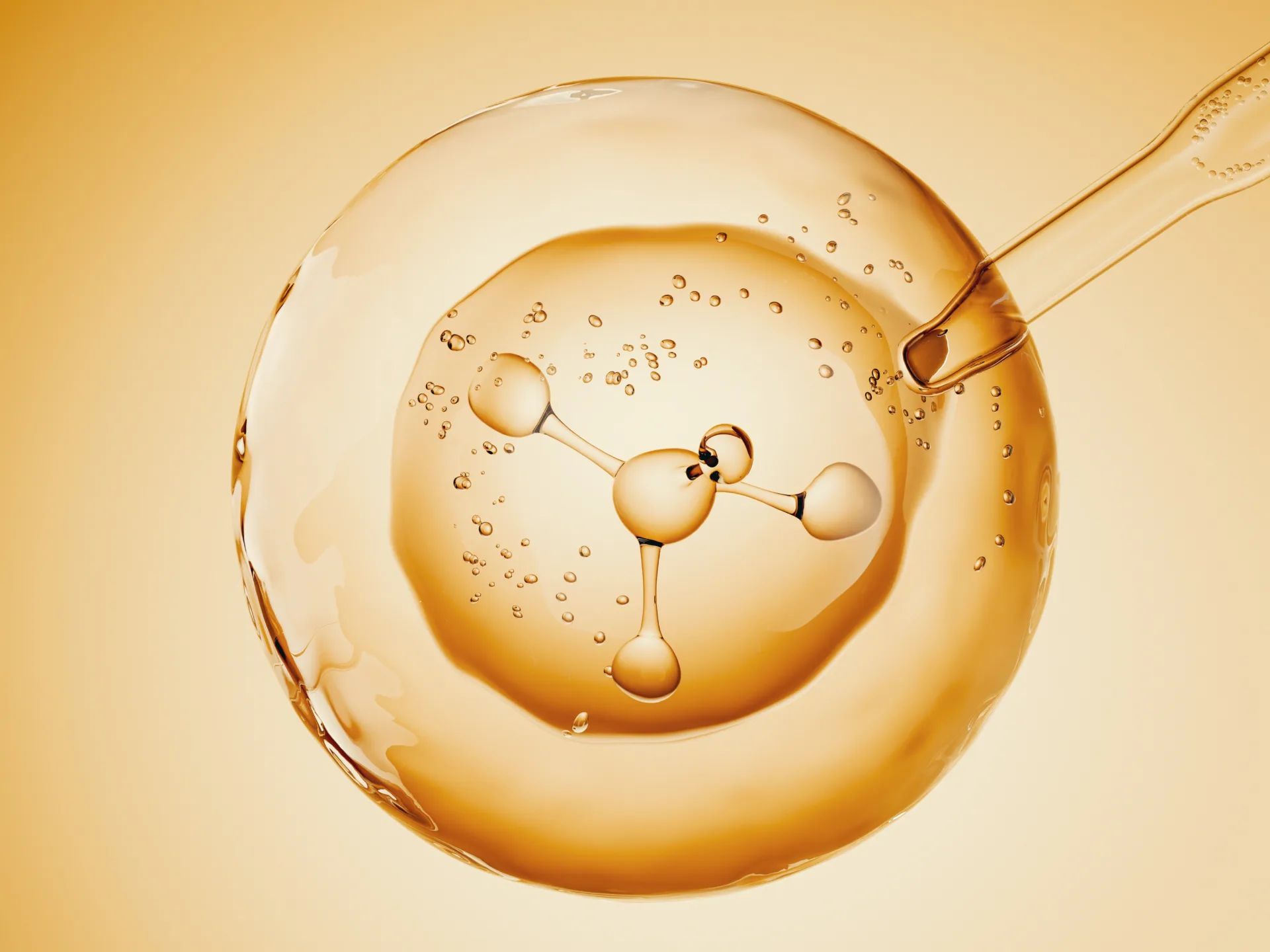 Pipette adding a drop to a golden sphere