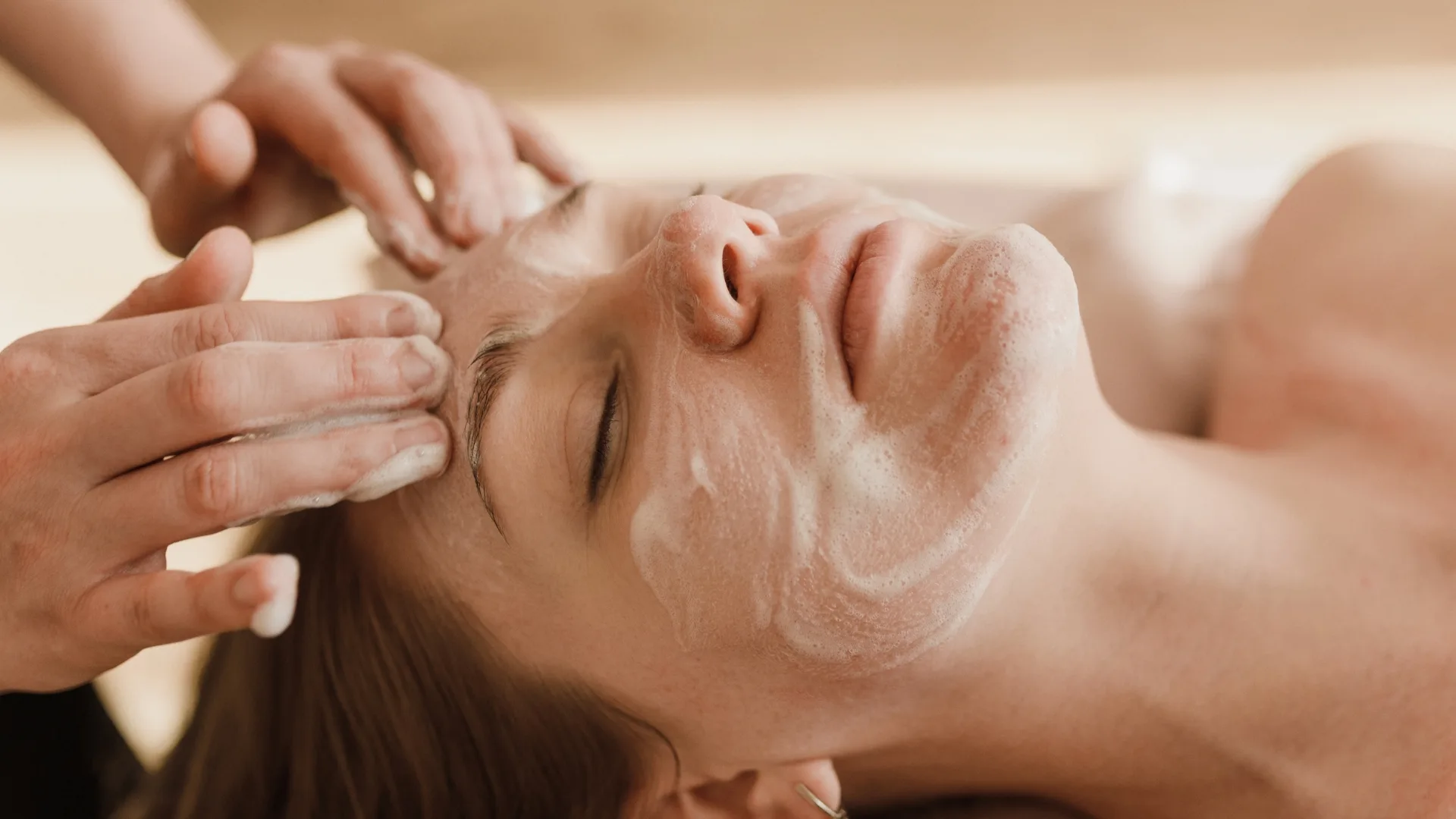 Client relaxing with a facial mask