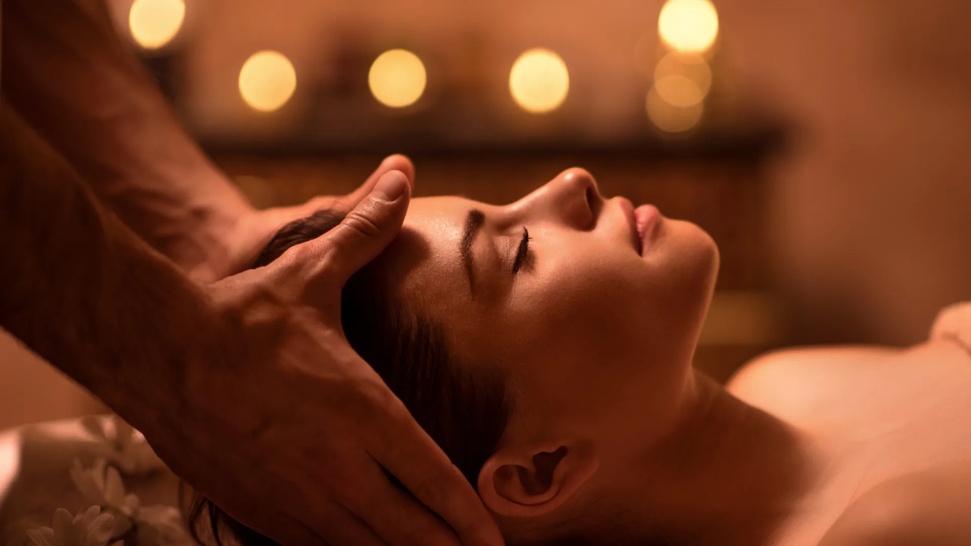Facial massage in a candlelit spa room