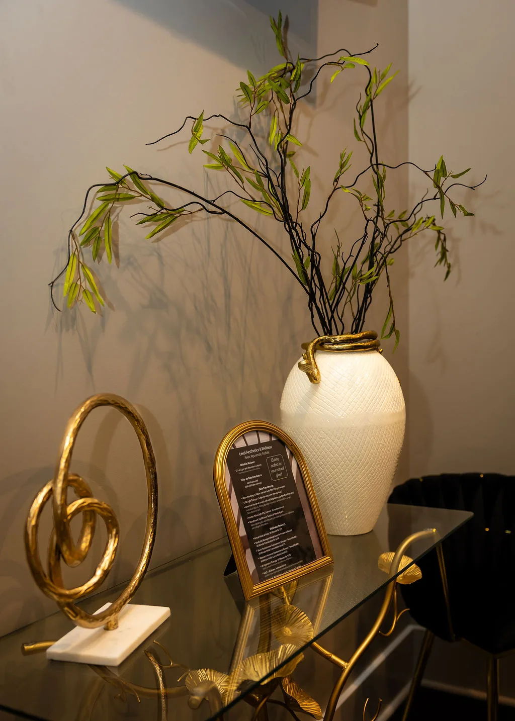 Gold-trimmed vase with greenery and a Lexel service menu in the studio