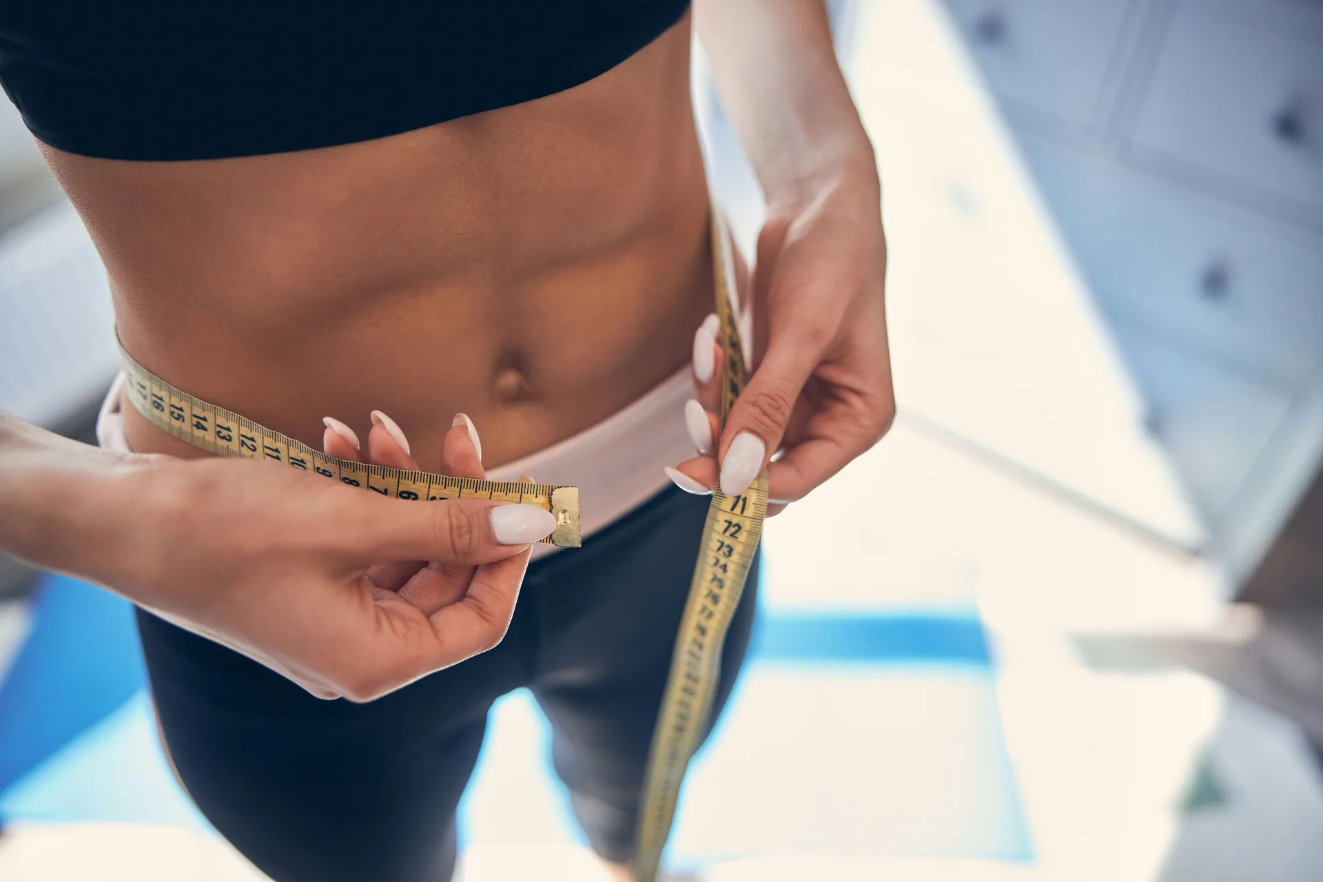 Woman tracking her progress with a measuring tape