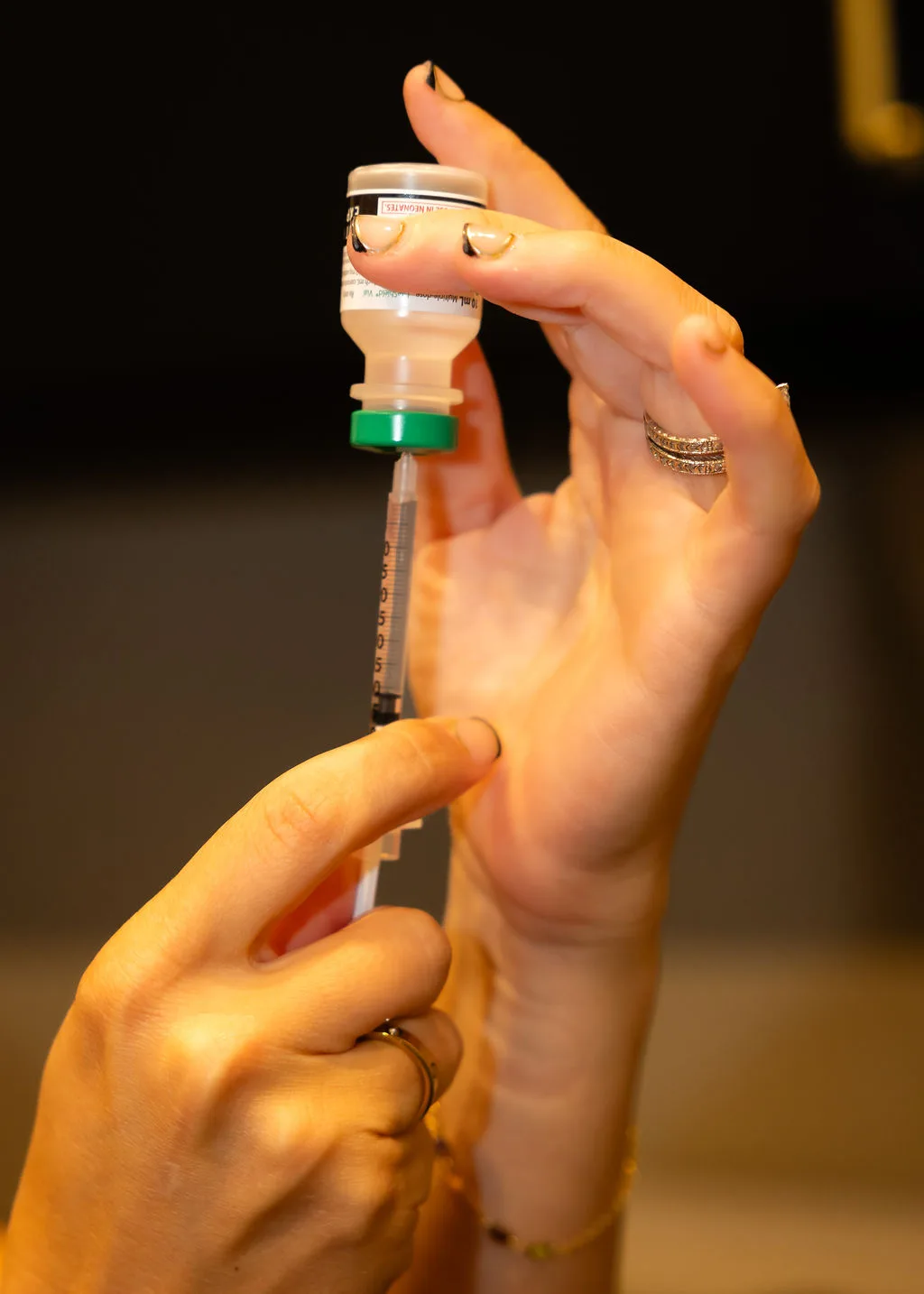 Provider drawing up a prescribed dose from a vial