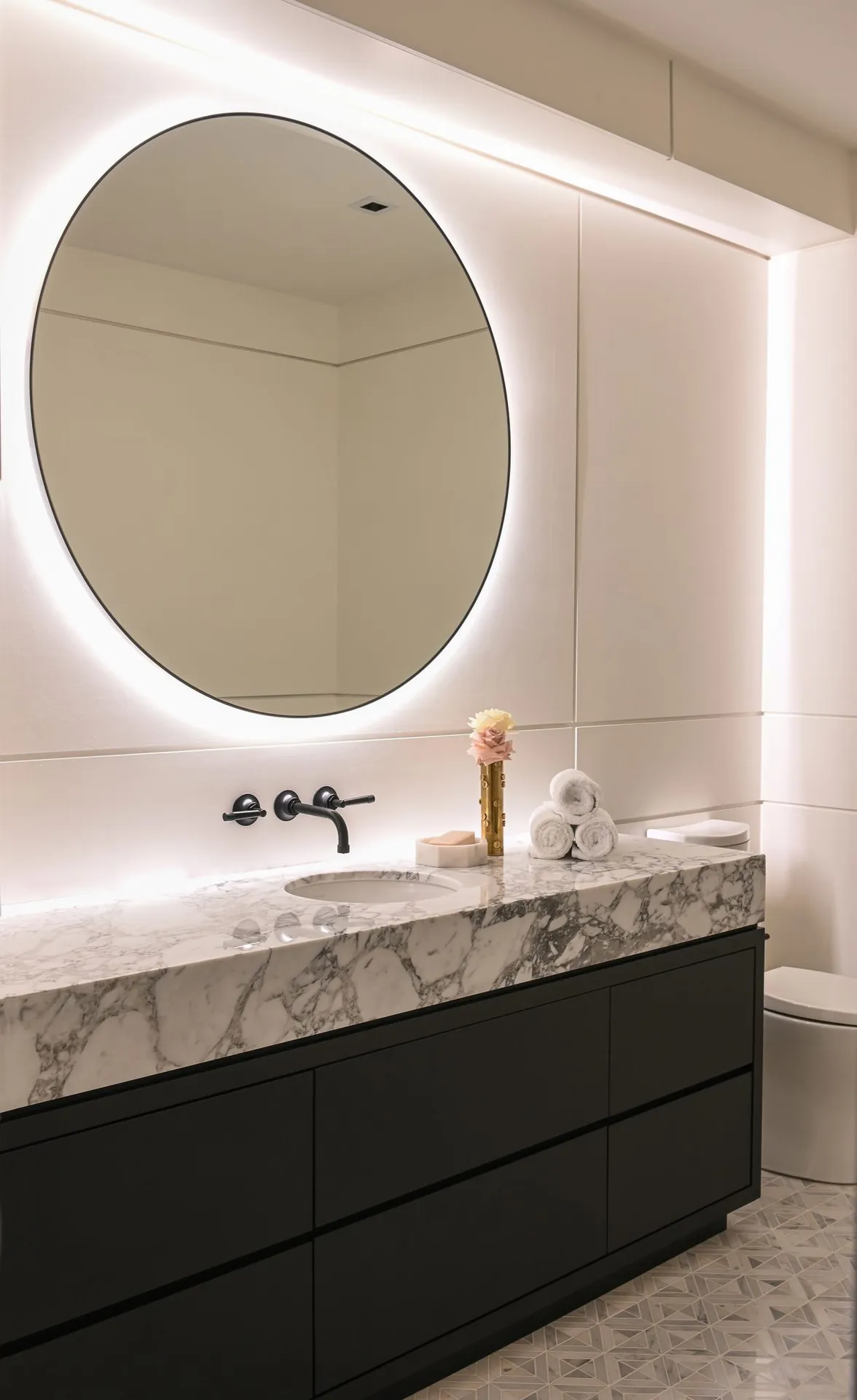 Powder room with black vanity, painting in the Ferme Moderne custom home