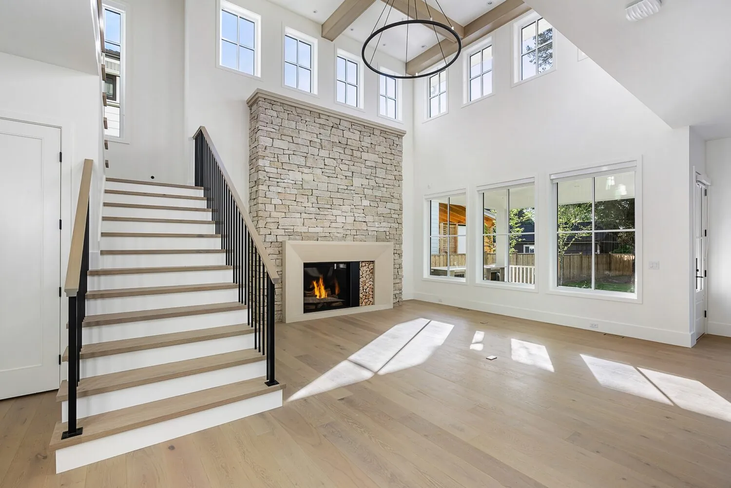 Great room with staircase and stone fireplace, interior painting in the Glover custom home