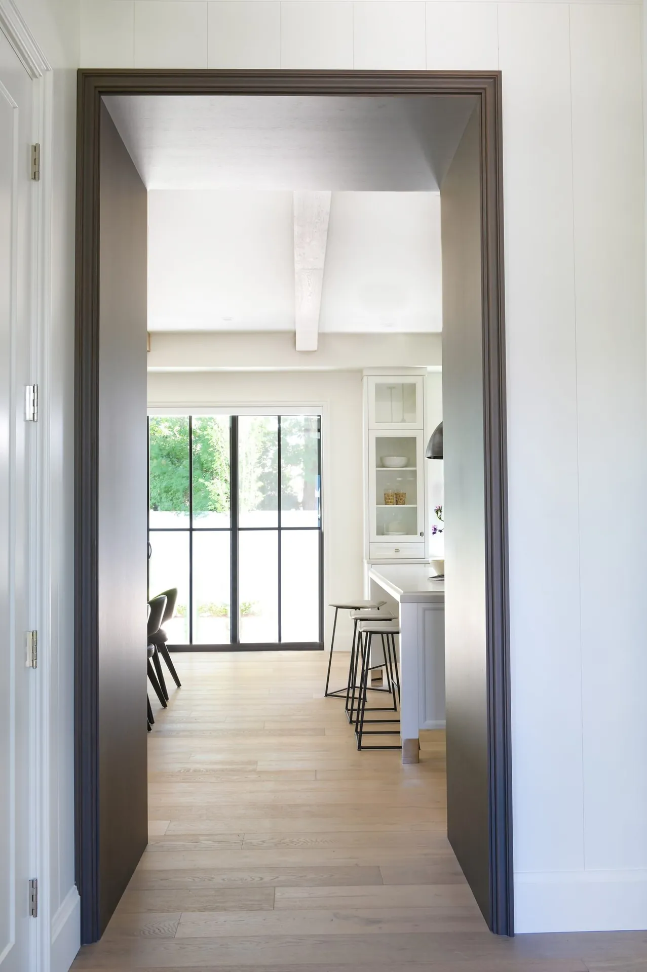 Hallway with dark door trim painting in the Noir custom home