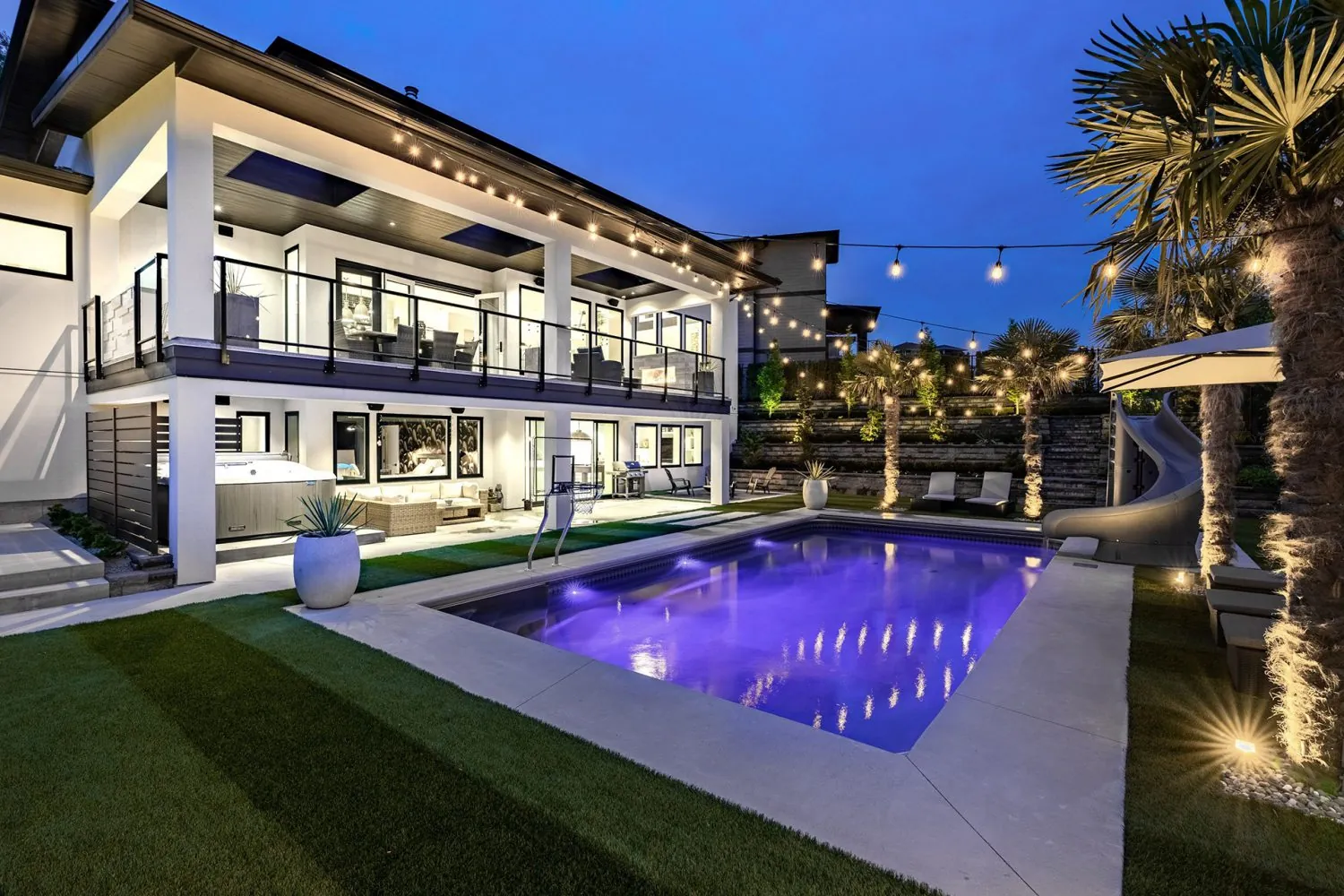 Backyard pool at dusk and exterior painting of the Palm custom home by Shaan Painting