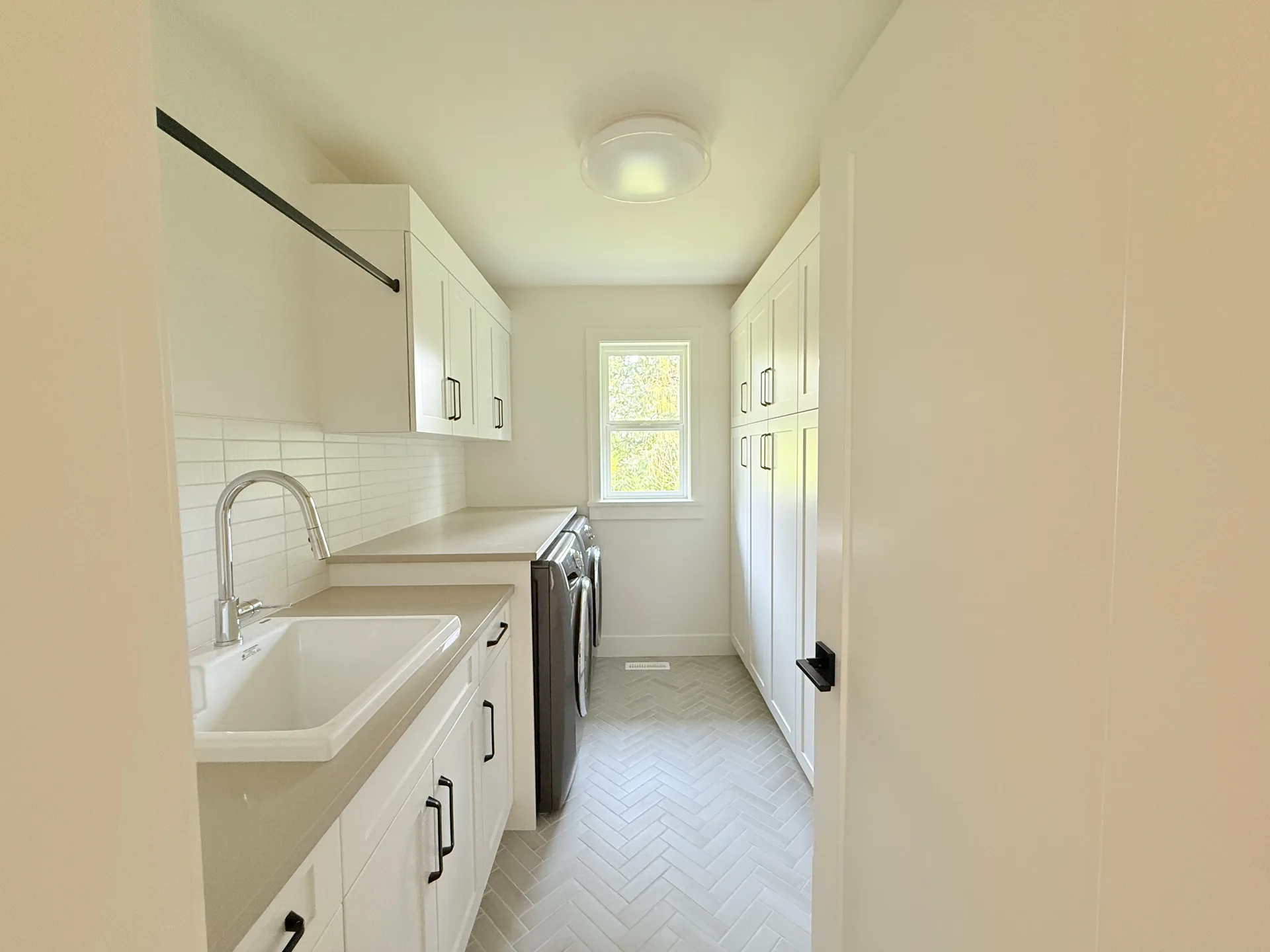 Laundry room with white cabinets and painted walls