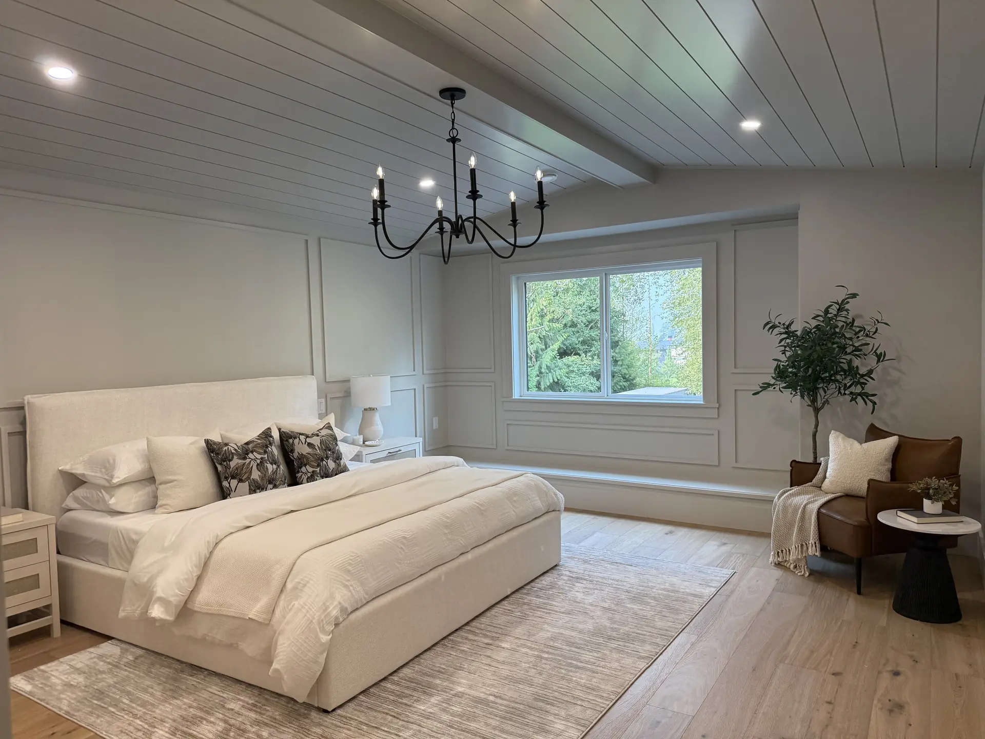 Primary bedroom with panelled feature wall and shiplap ceiling