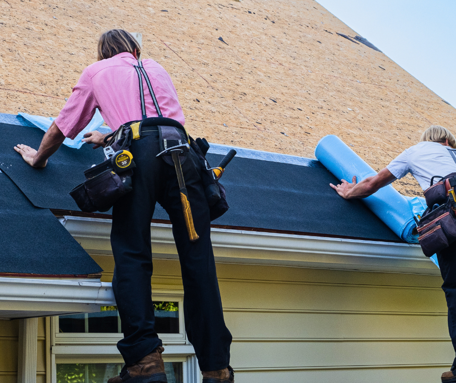 Roofers installing roofing material on a house, demonstrating hands-on work in the construction sector, relevant to local business visibility and Google Ads management.