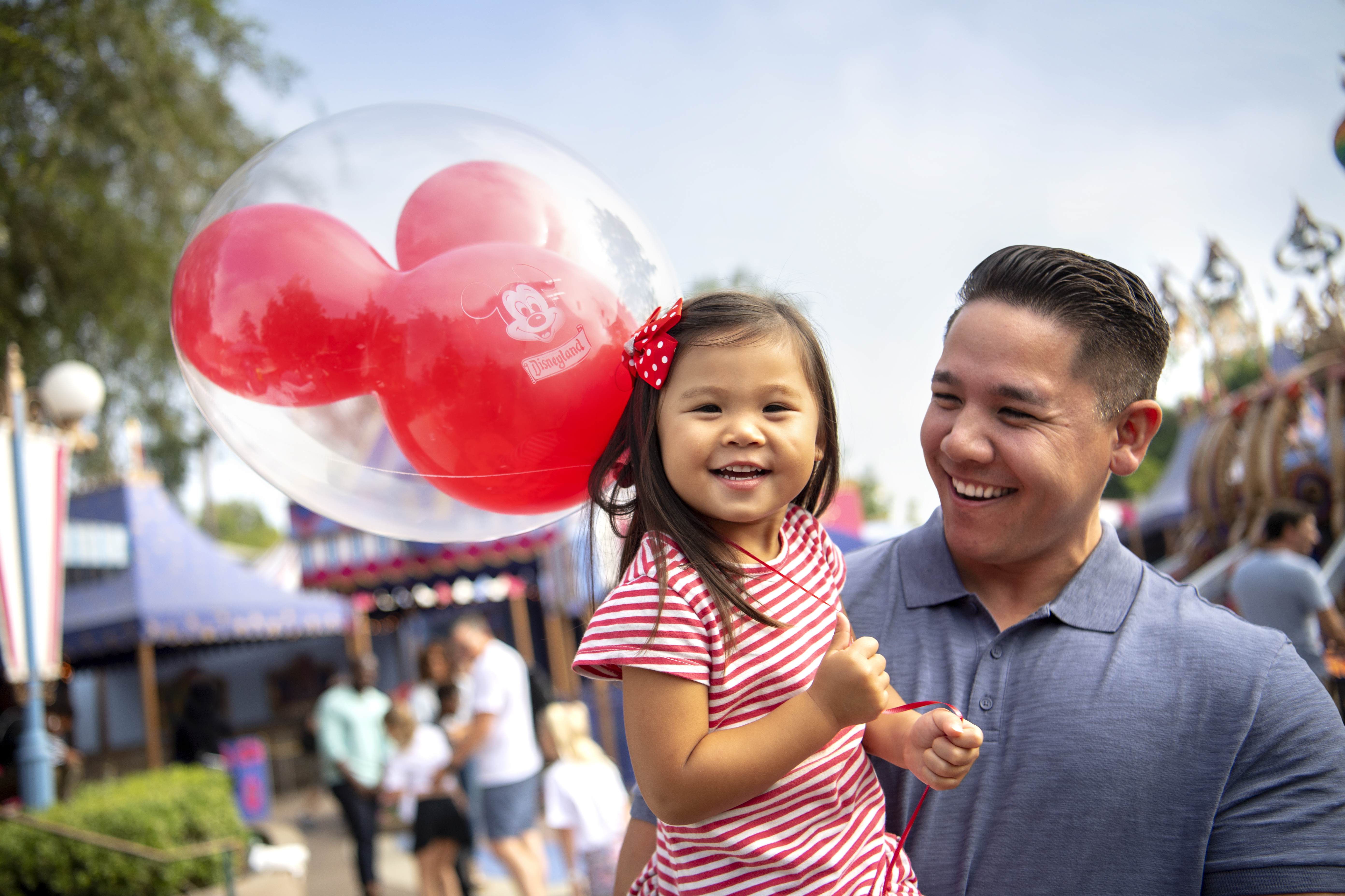 Father and toddler daughter smiling with Mickey Mouse balloon at Disneyland Resort, Anaheim California Father and toddler daughter smiling with Mickey Mouse balloon at Disneyland Resort, Anaheim California