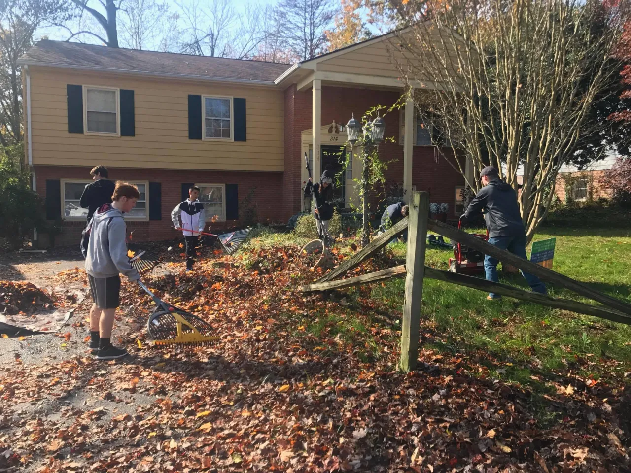 HomeWork 4 Heroes volunteer crew raking and repairing a fence at a real project home