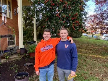 Two HomeWork 4 Heroes volunteers in UVA gear at a real project home