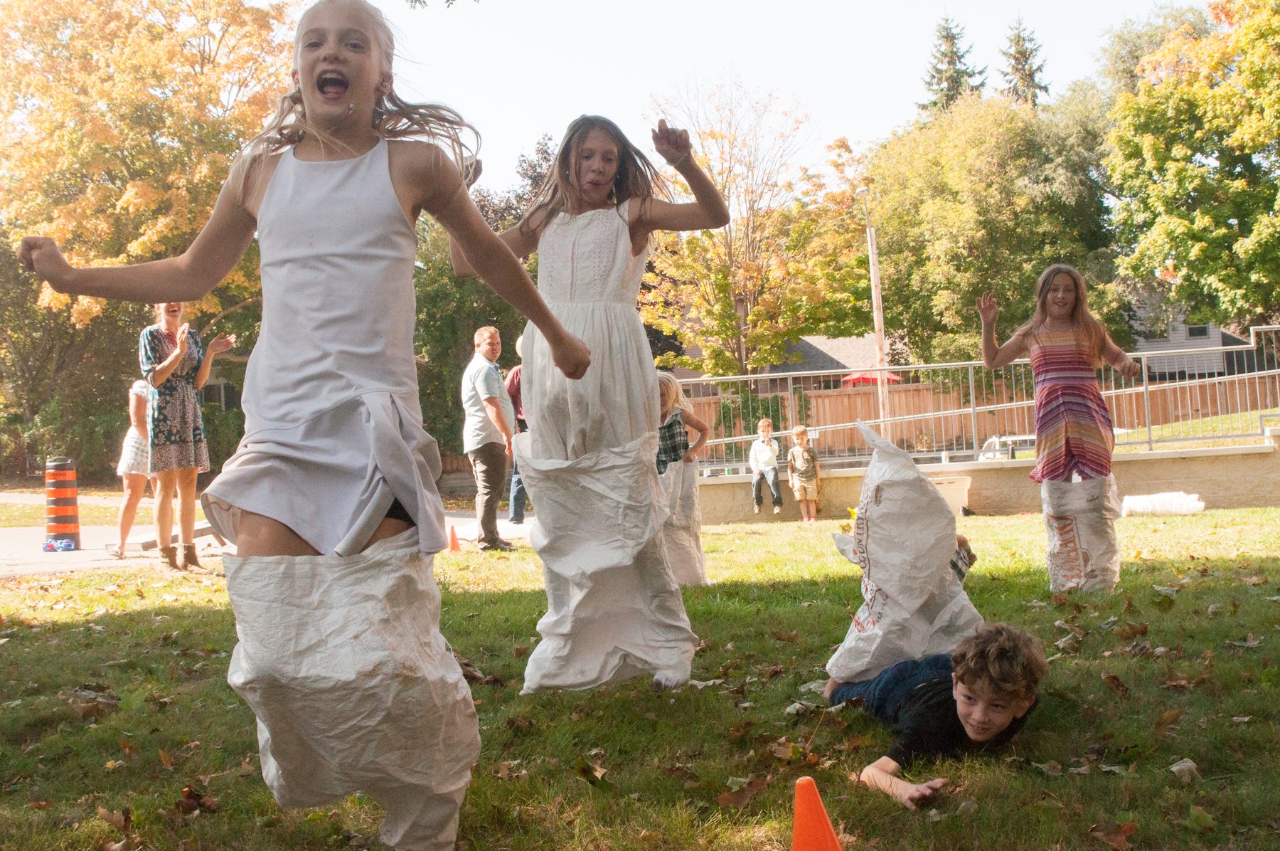 Two girls laughing mid jump during the sack race