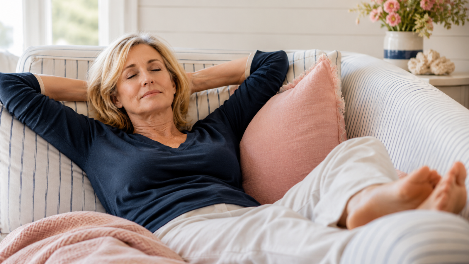 Woman resting on a sofa, eyes closed, peaceful