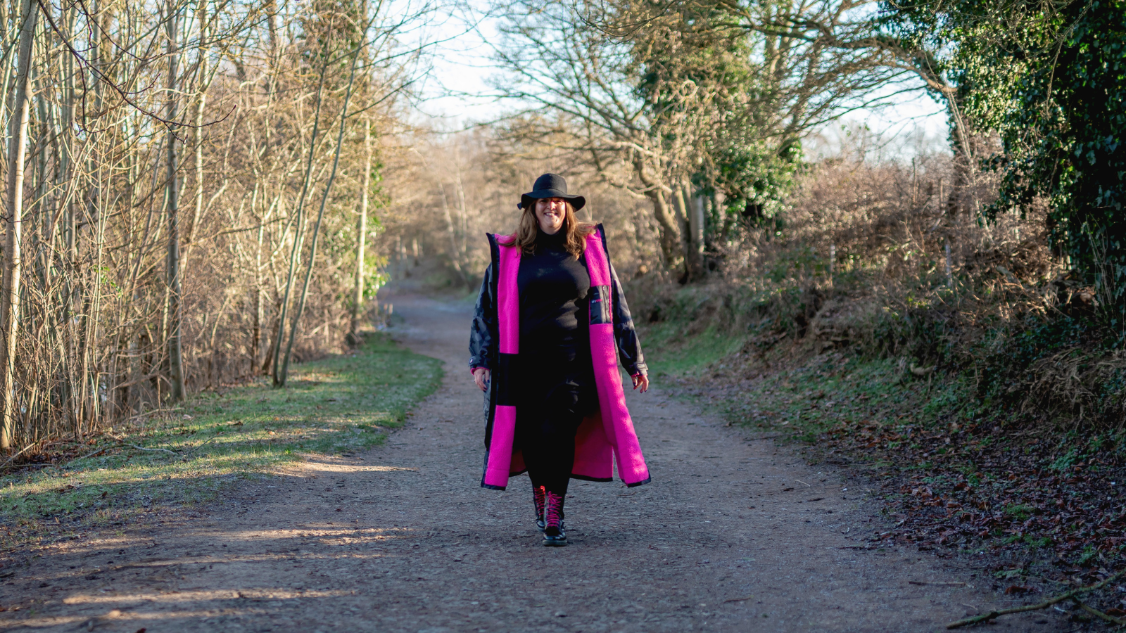 Clare Deacon walking on a path through woodland