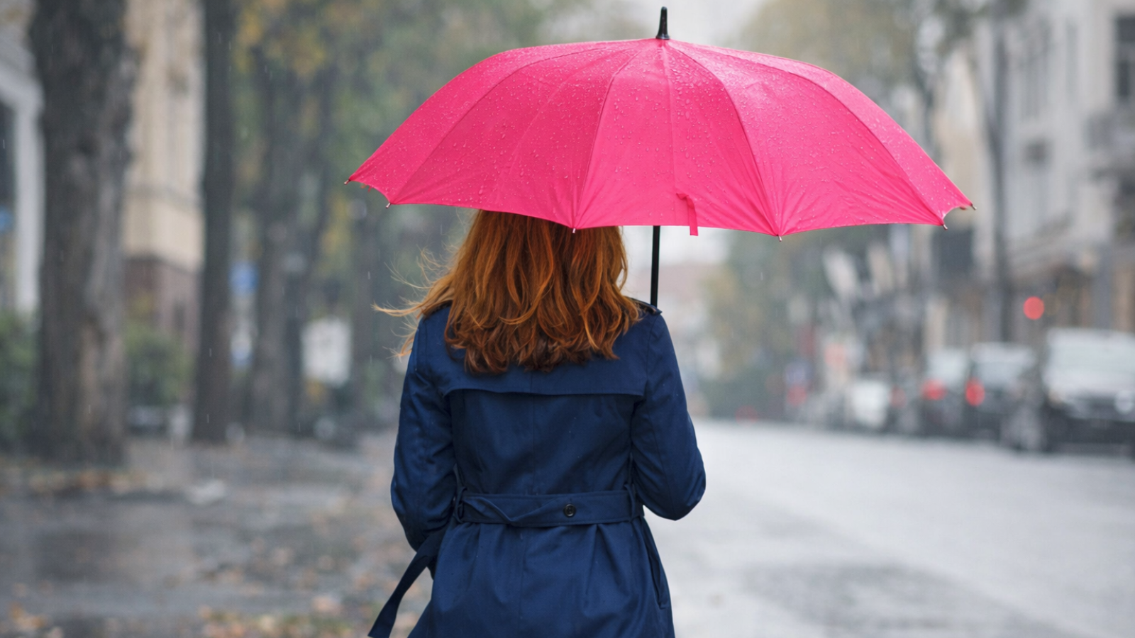 Woman with a pink umbrella walking in the rain