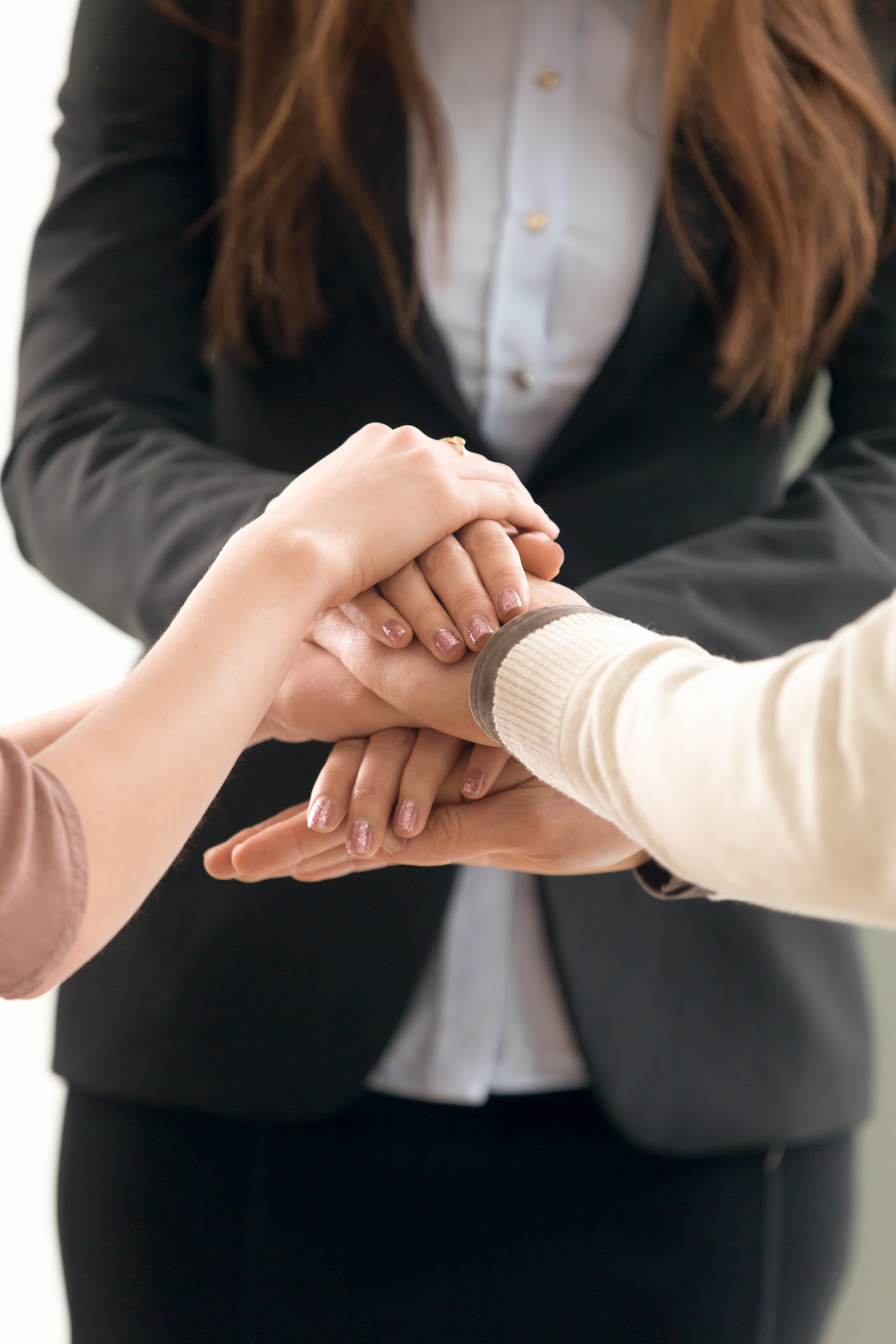 Business team joining hands building a real coaching culture