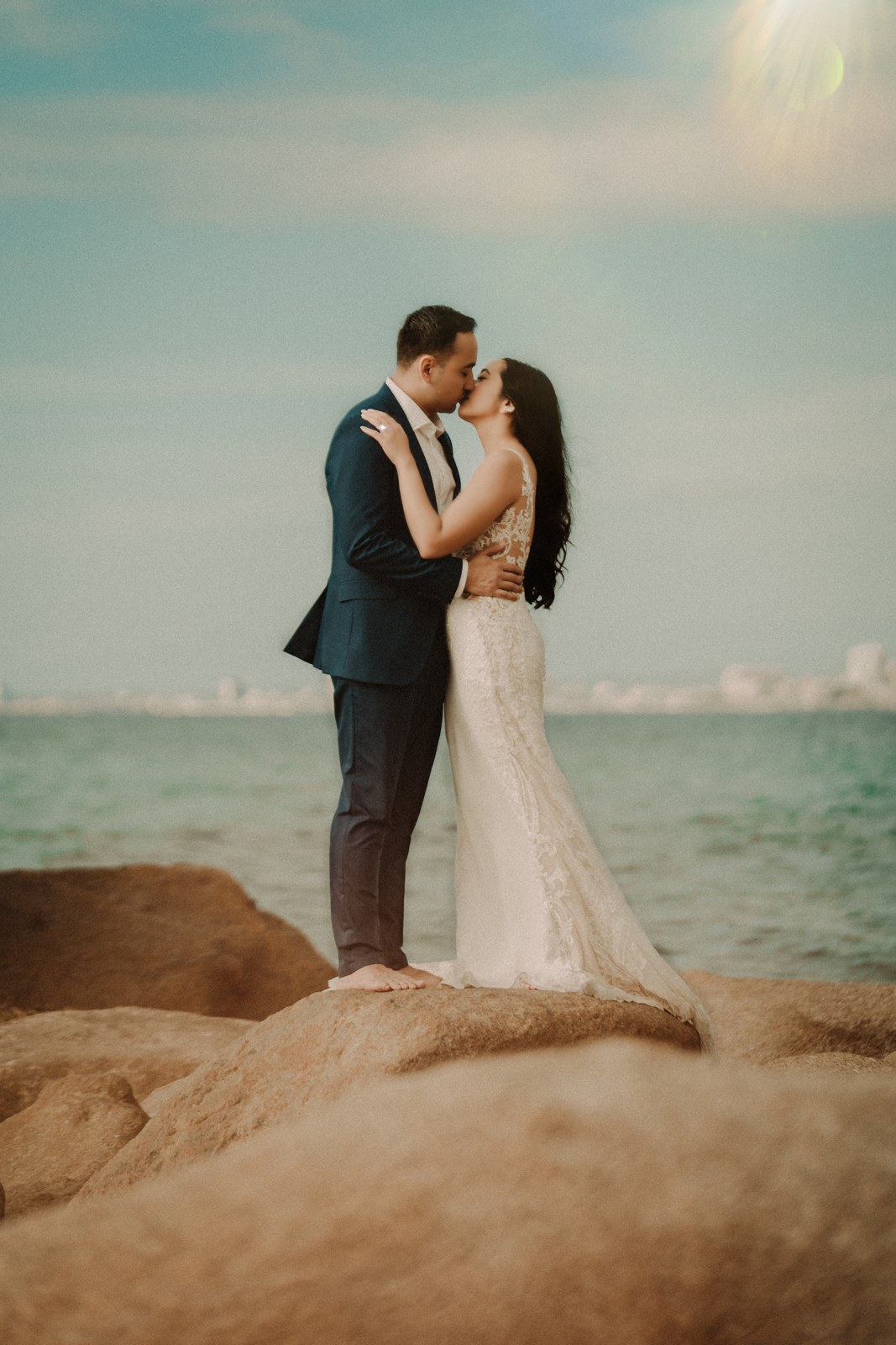 A couple kissing on seaside rocks