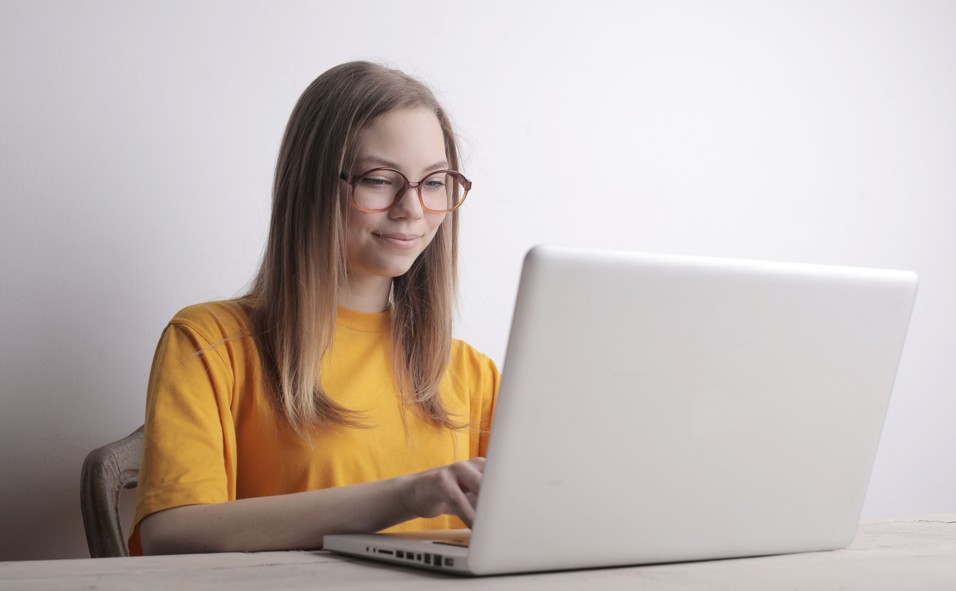 Woman wearing computer glasses while working on a laptop Woman wearing computer glasses while working on a laptop