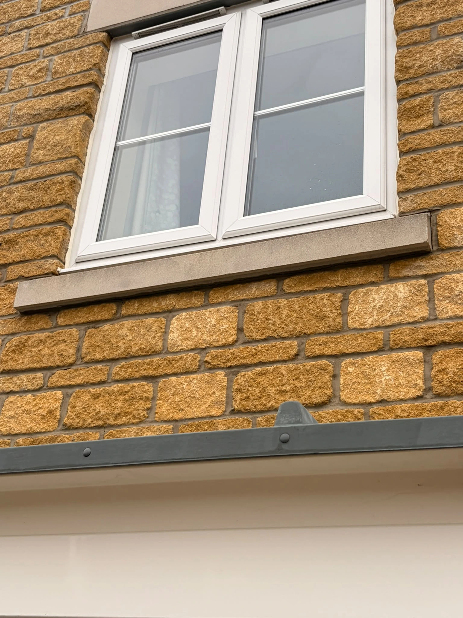Upstairs stone window sill in Gloucester after soft washing, brightened and restored by Glevum Hydro