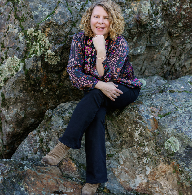Radha Heartwell sitting among rocks