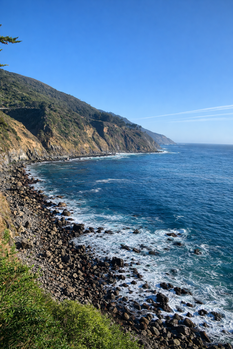 A road cut into a cliff face above the open ocean